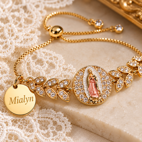Close-up of gold Mother Mary medal bracelet with leaf links, clear stones and a personalized round charm