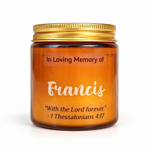 Personalized memorial candle in an amber glass jar with a gold lid, label with the name Francis