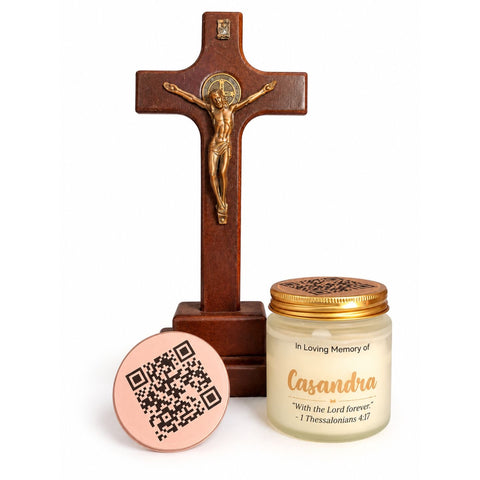 Casandra memorial candle with a gold lid beside a crucifix and a rose-gold QR code lid